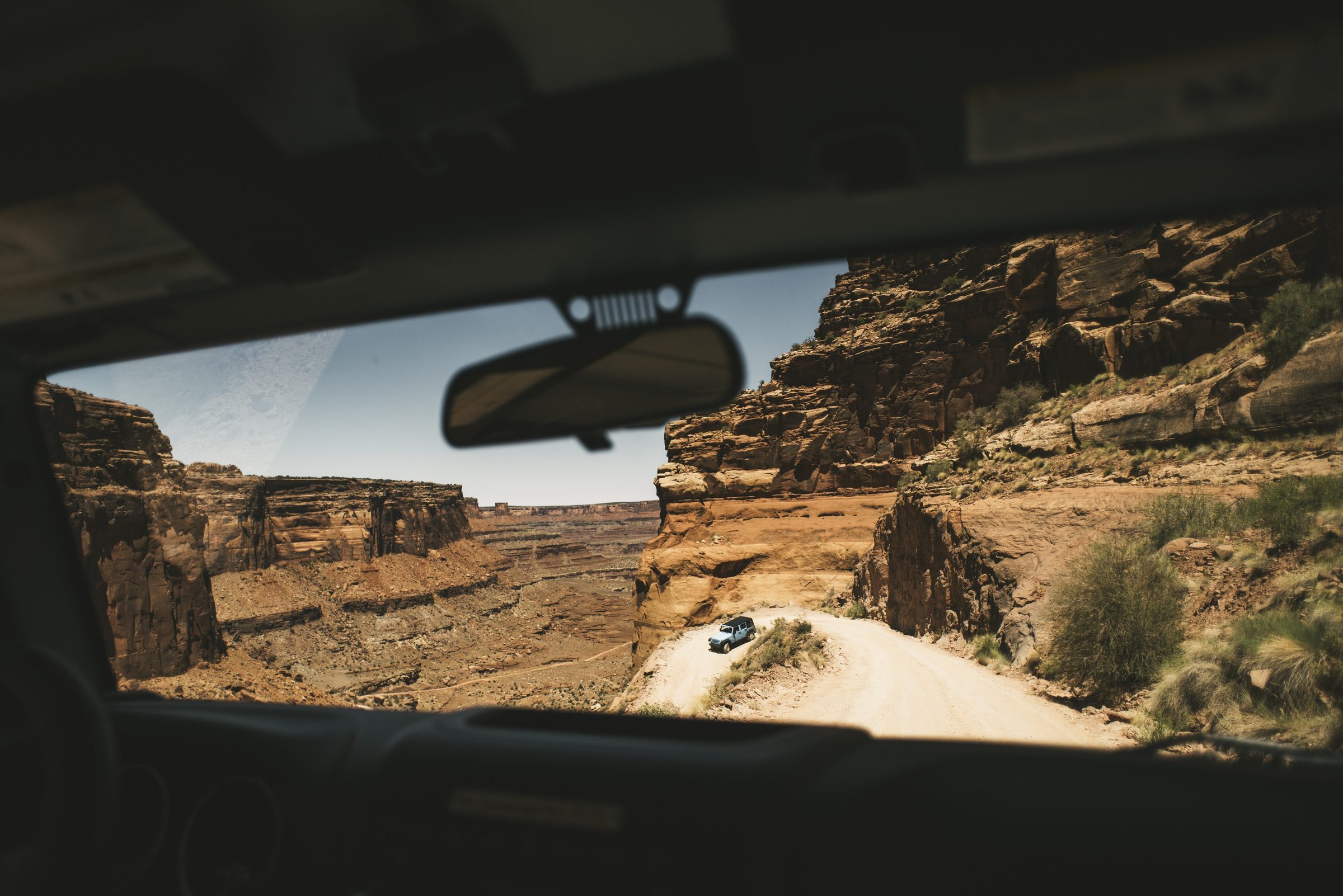 View through a windshield of a Jeep ahead on a canyon road