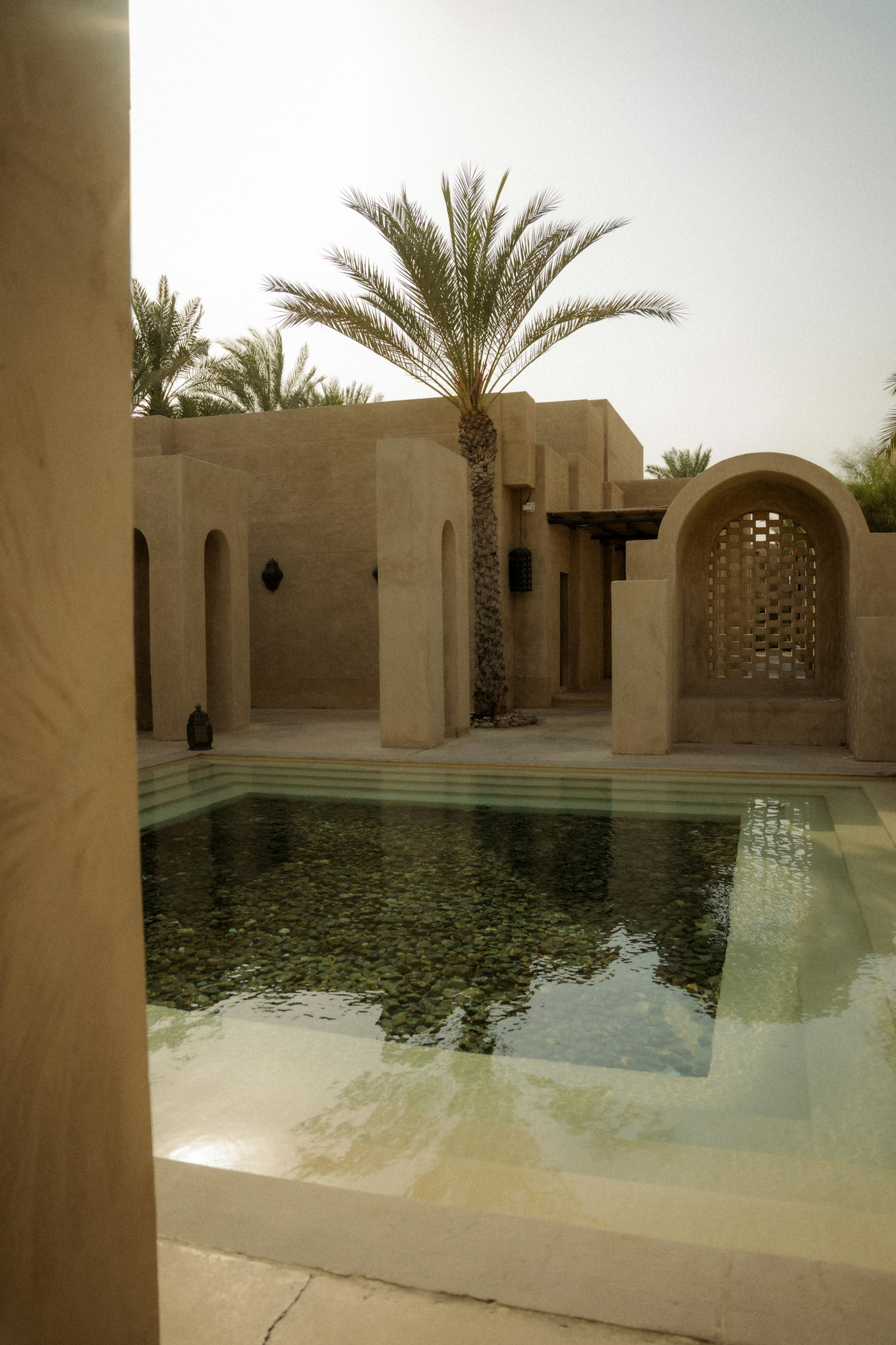 Sandstone resort courtyard with a still reflecting pool